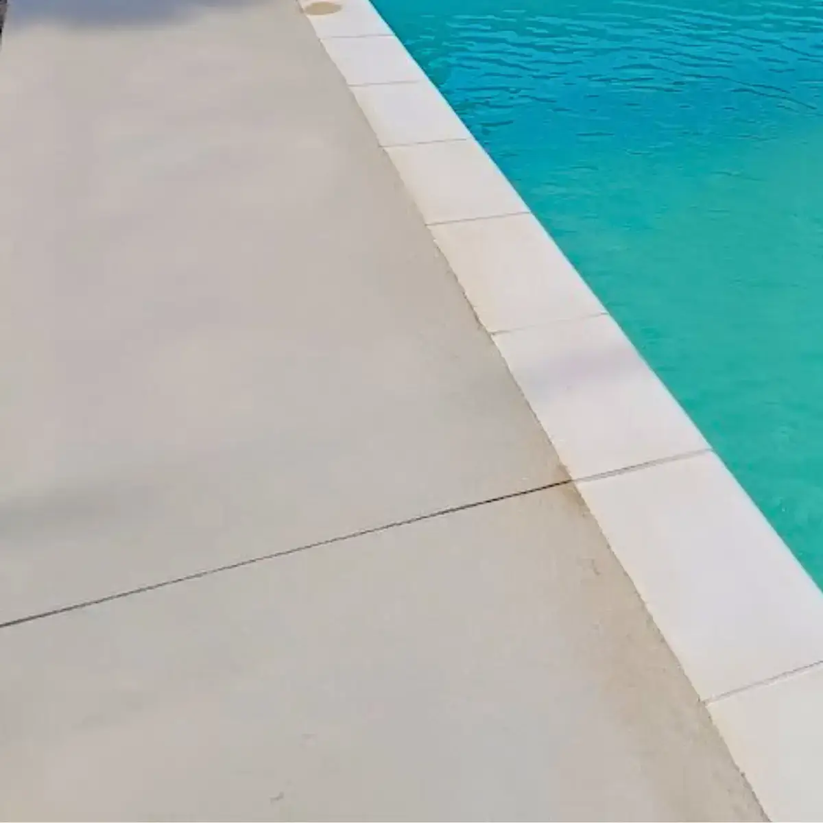 Terrasse piscine en béton taloché fin clair, finition lisse et soignée