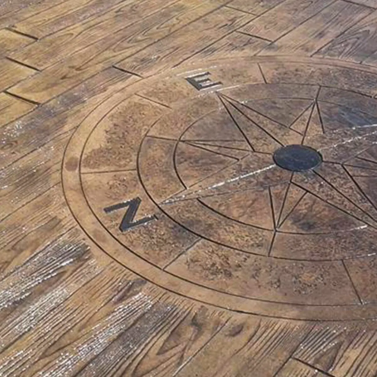 Terrasse en béton empreinte imitation bois avec boussole décorative